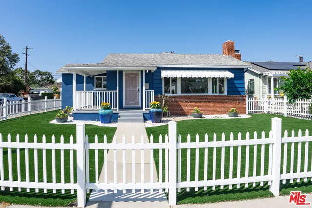 a front view of a house with a yard table and chairs