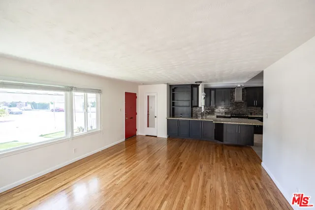 a large kitchen with a wooden floor and large windows