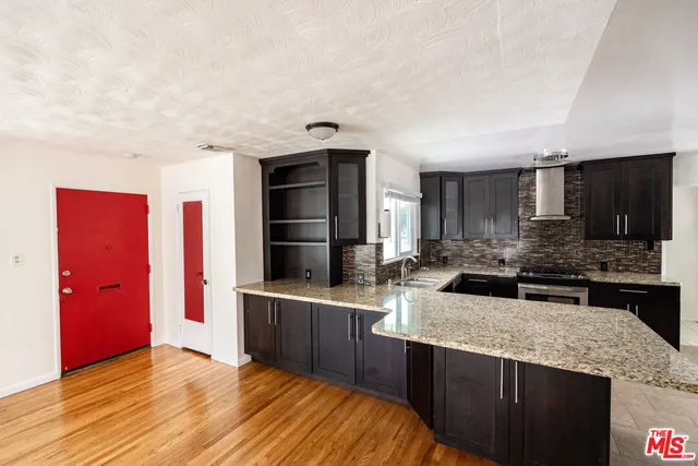 a kitchen with stainless steel appliances granite countertop a sink and refrigerator