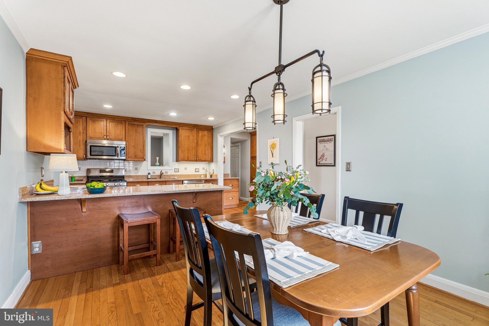 318 Alabama Road Towson, MD 21204 - Photo 16 of 72 a kitchen with stainless steel appliances kitchen island granite countertop a dining table chairs and white cabinets