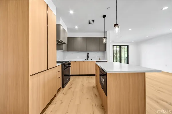 a kitchen with kitchen island a sink stainless steel appliances and cabinets