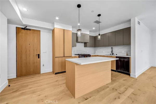 a large kitchen with stainless steel appliances kitchen island granite countertop a stove a sink and a refrigerator