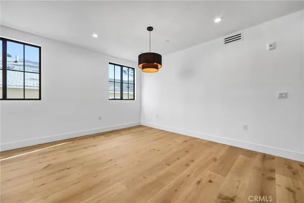 a view of an empty room with window and chandelier