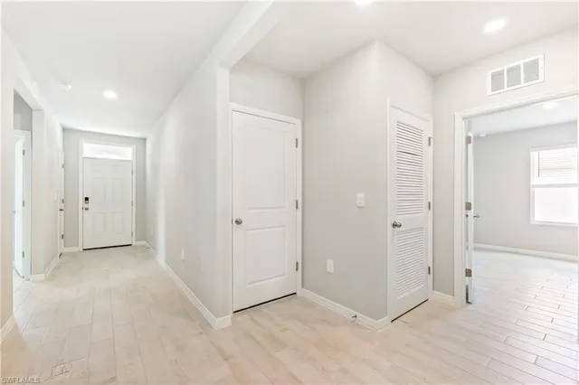 an empty room with windows and closet