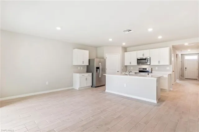 a large white kitchen with stainless steel appliances cabinets