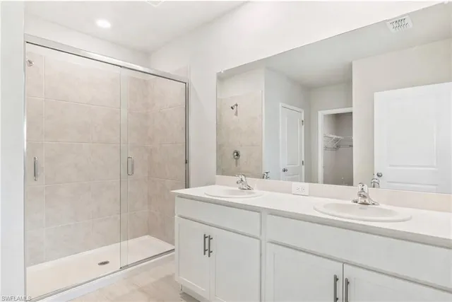 a bathroom with a shower sink vanity and mirror