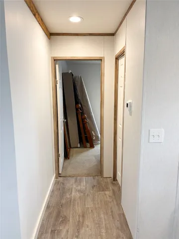 a view of a hallway with wooden shelves