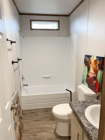 a bathroom with a granite countertop toilet sink and mirror