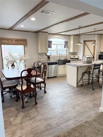 a living room with stainless steel appliances kitchen island granite countertop furniture and a large window