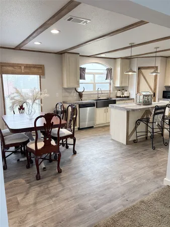 a living room with stainless steel appliances kitchen island granite countertop furniture and a large window
