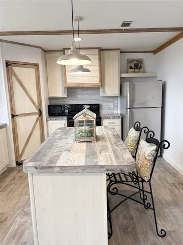 a kitchen with a table chairs and a wooden floor