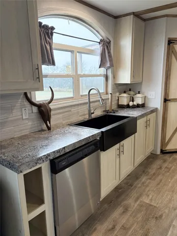 a kitchen with granite countertop a sink and a stove