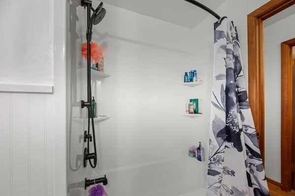 a bathroom with a shower curtain and a window