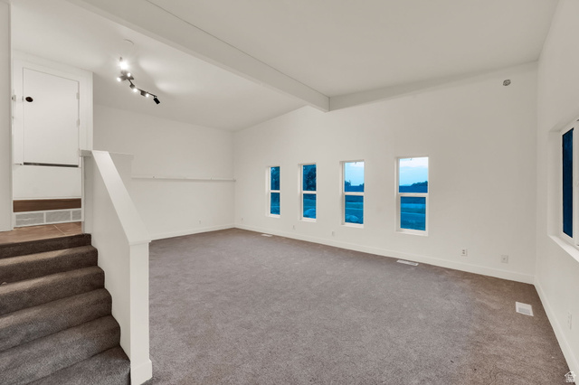 360 400 North Centerville, UT 84014 - Photo 17 of 30 Spacious room featuring vaulted ceilings, track lighting, neutral wall finishes, carpeted flooring, and multiple windows