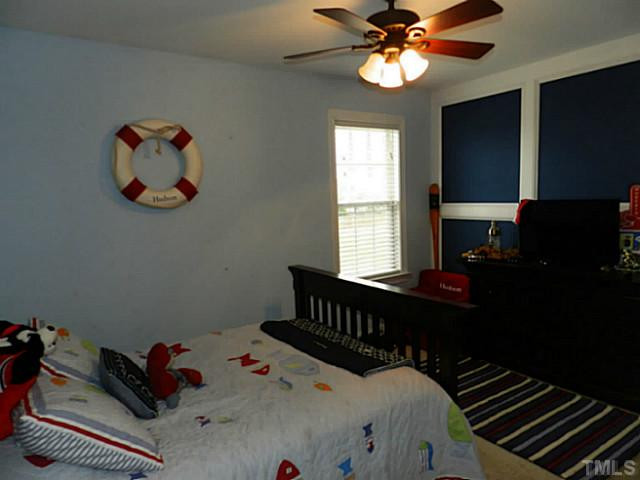 343 Ina Joe Place Willow Spring, NC 27592 - Photo 15 of 23 a bedroom with a bed and a chandelier