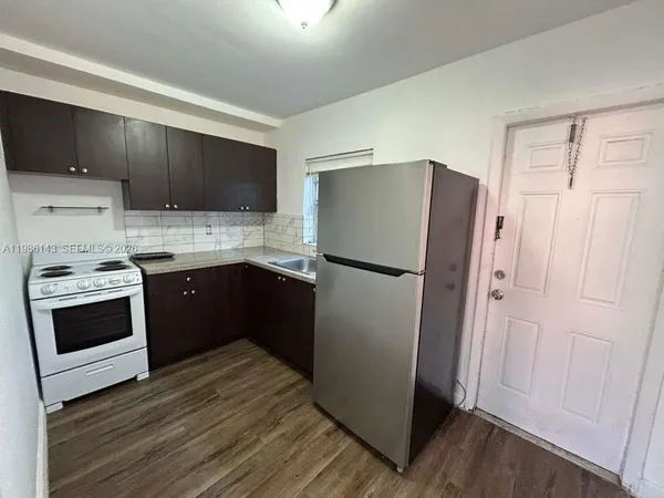 a kitchen with a refrigerator sink and cabinets
