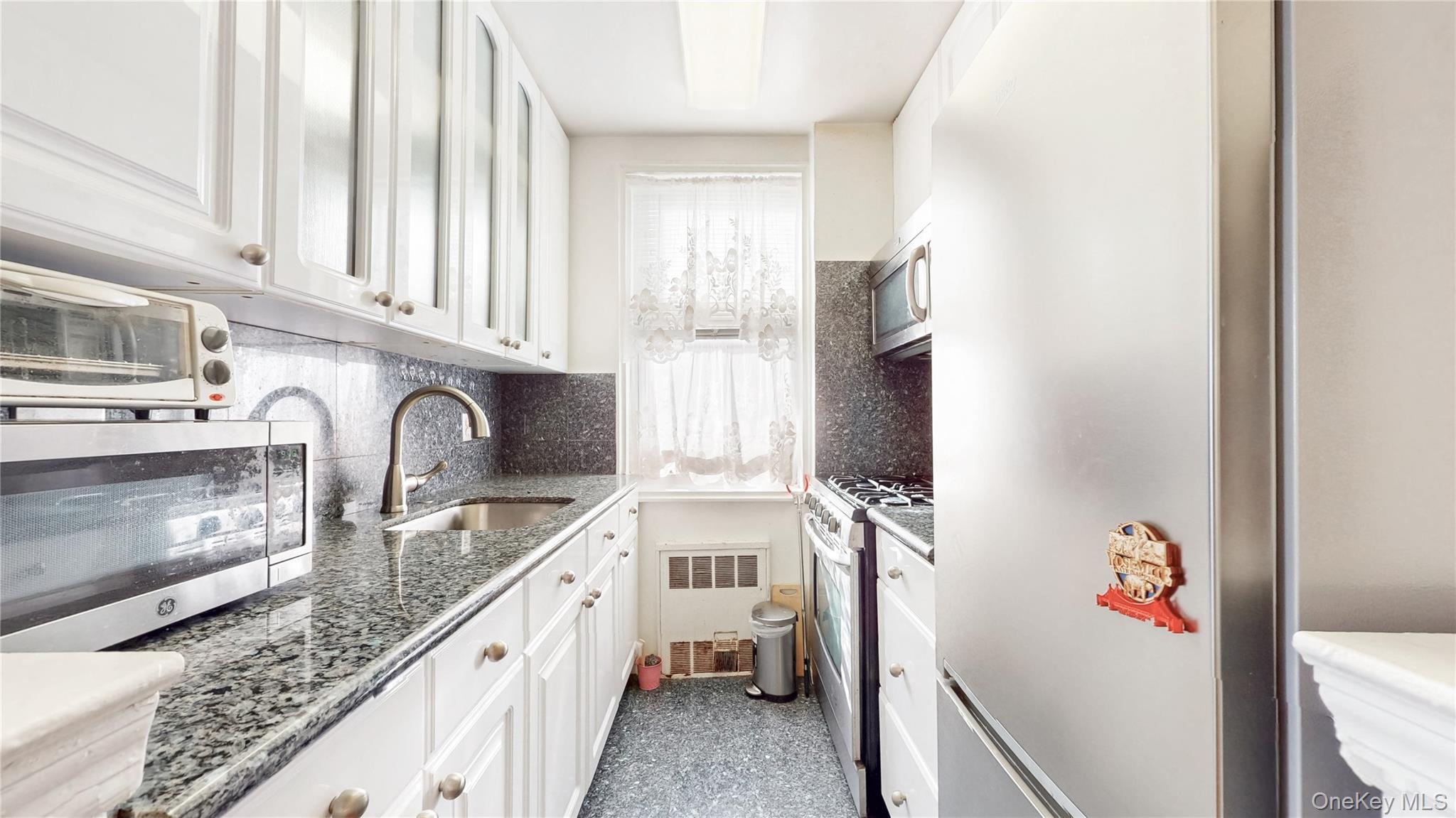67-40 Booth Street, Unit 4O Queens, NY 11375 - Photo 11 of 19 a kitchen with stainless steel appliances granite countertop a sink stove and refrigerator