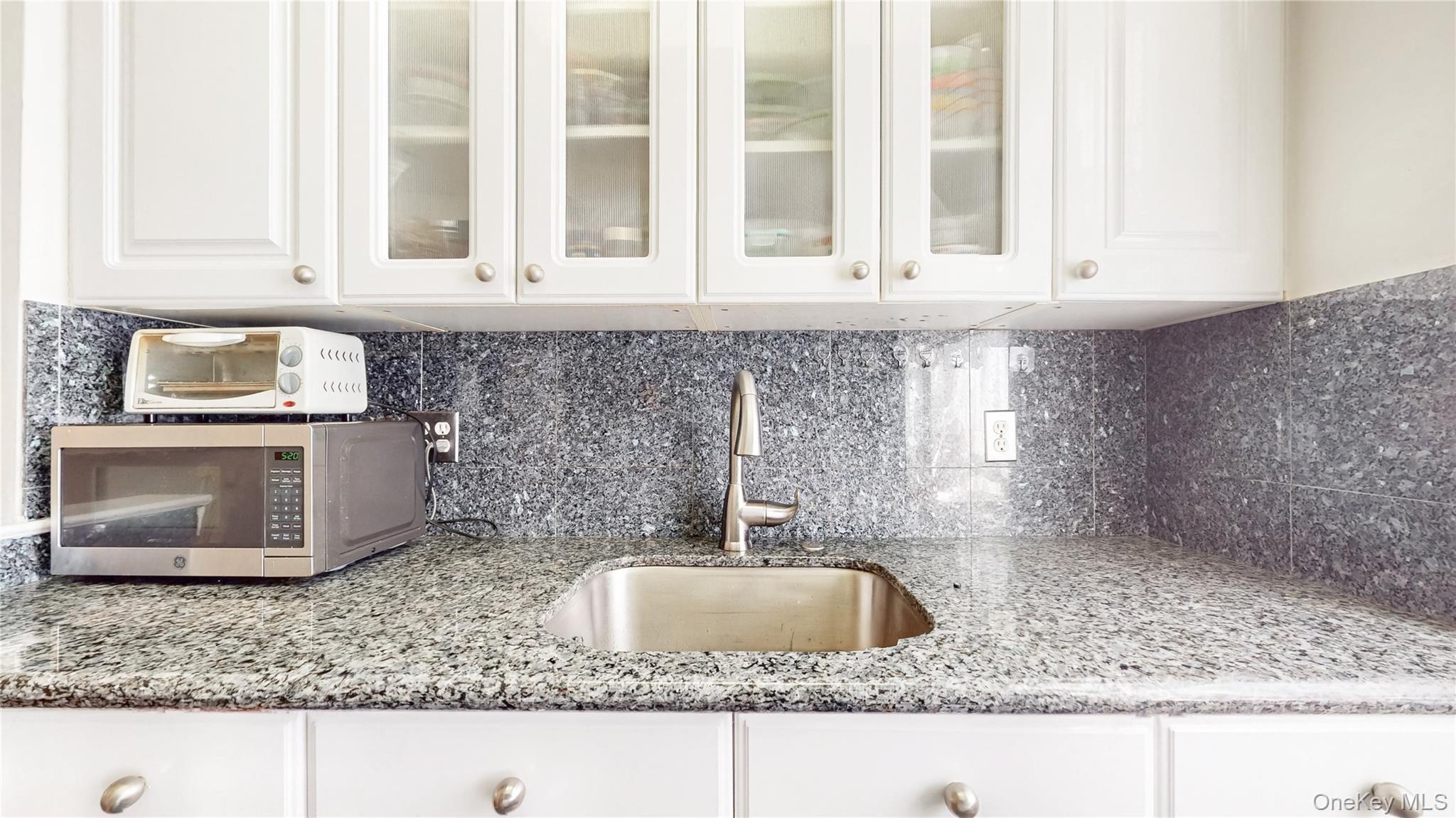 67-40 Booth Street, Unit 4O Queens, NY 11375 - Photo 12 of 19 a kitchen with granite countertop a sink and a stove