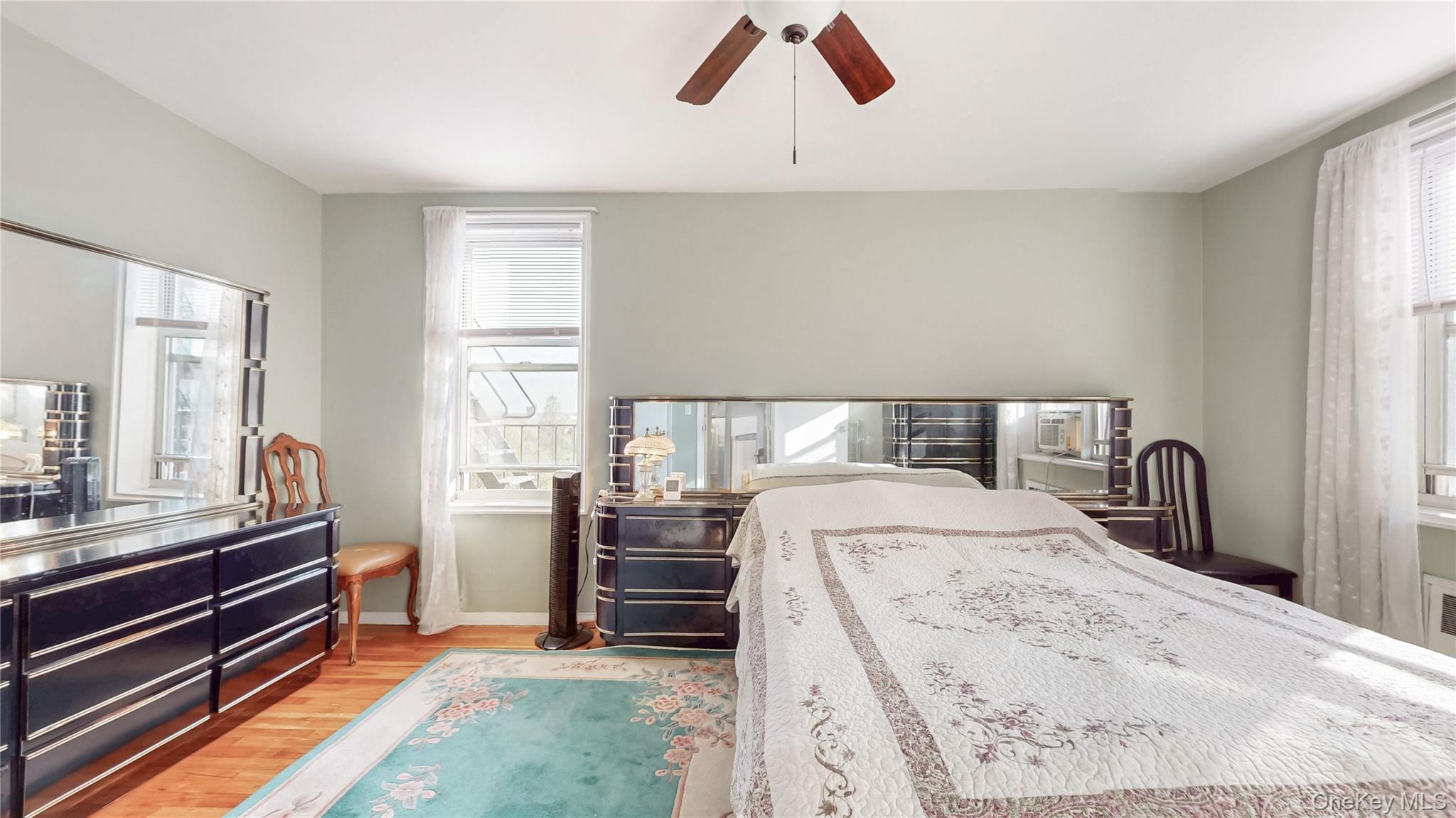 67-40 Booth Street, Unit 4O Queens, NY 11375 - Photo 13 of 19 a bedroom with a bed and dresser with mirror