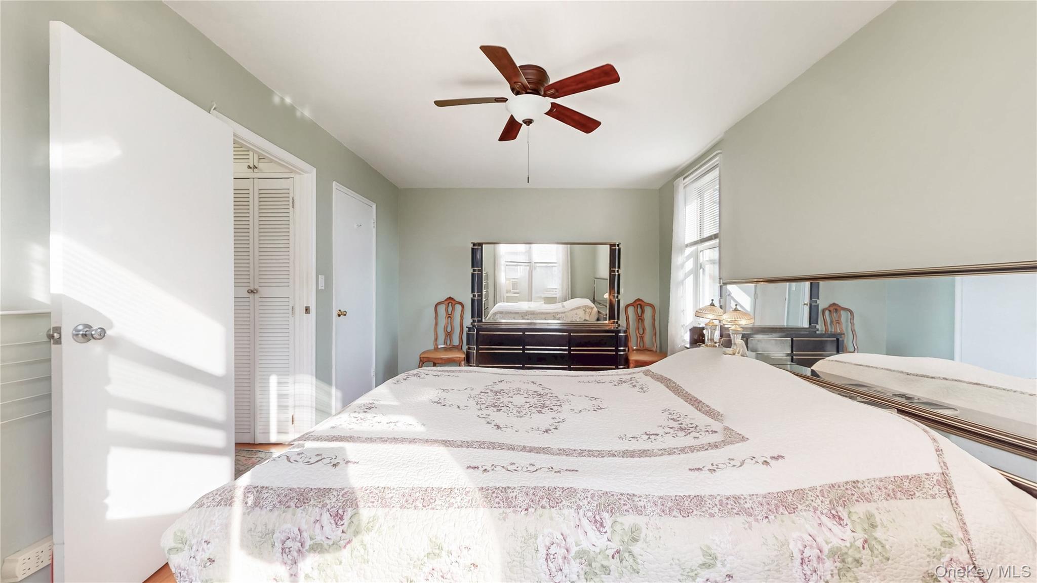 67-40 Booth Street, Unit 4O Queens, NY 11375 - Photo 15 of 19 a large bedroom with a large bed and a chandelier