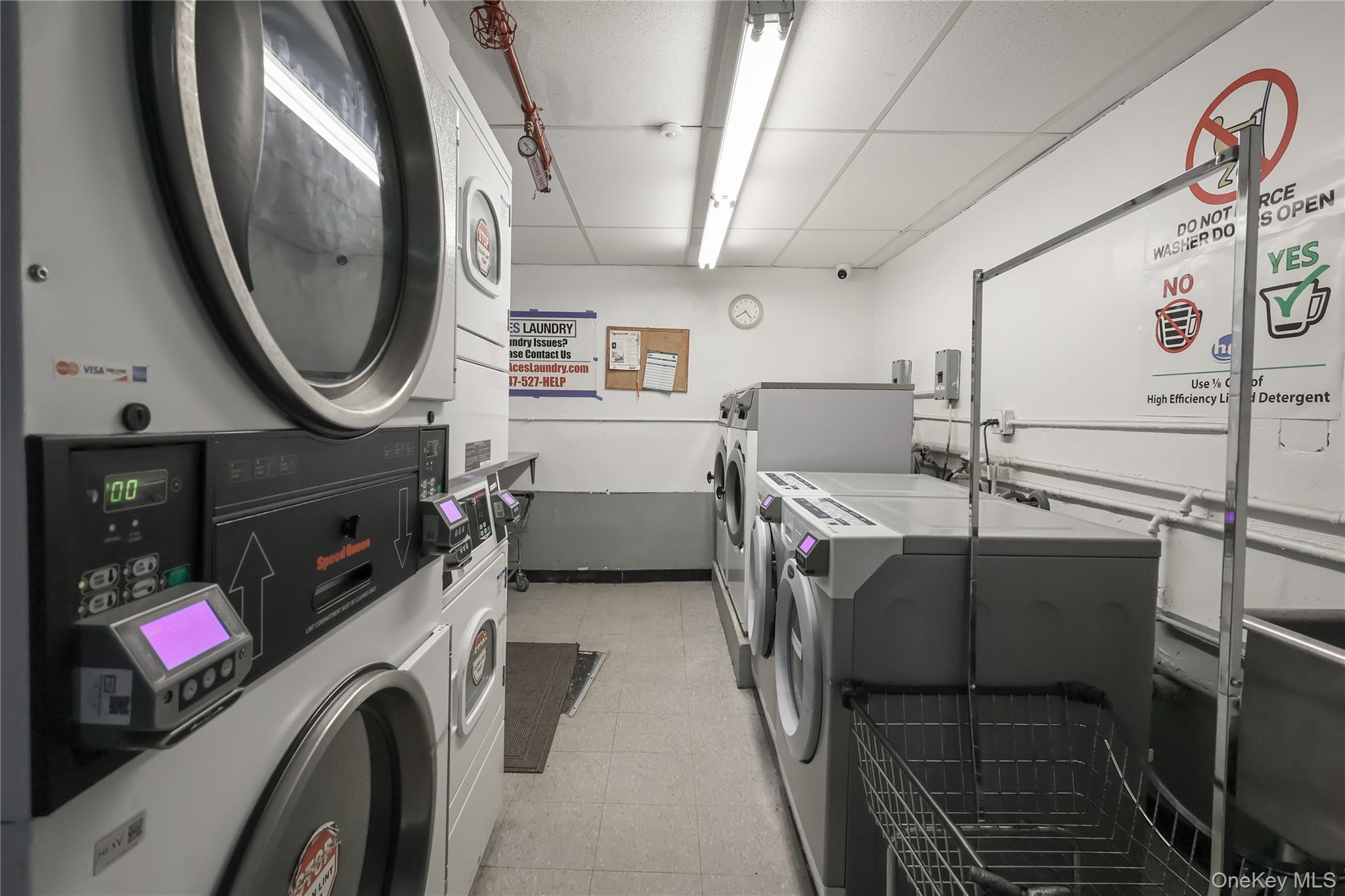 67-40 Booth Street, Unit 4O Queens, NY 11375 - Photo 17 of 19 a utility room with dryer washer and a mirror