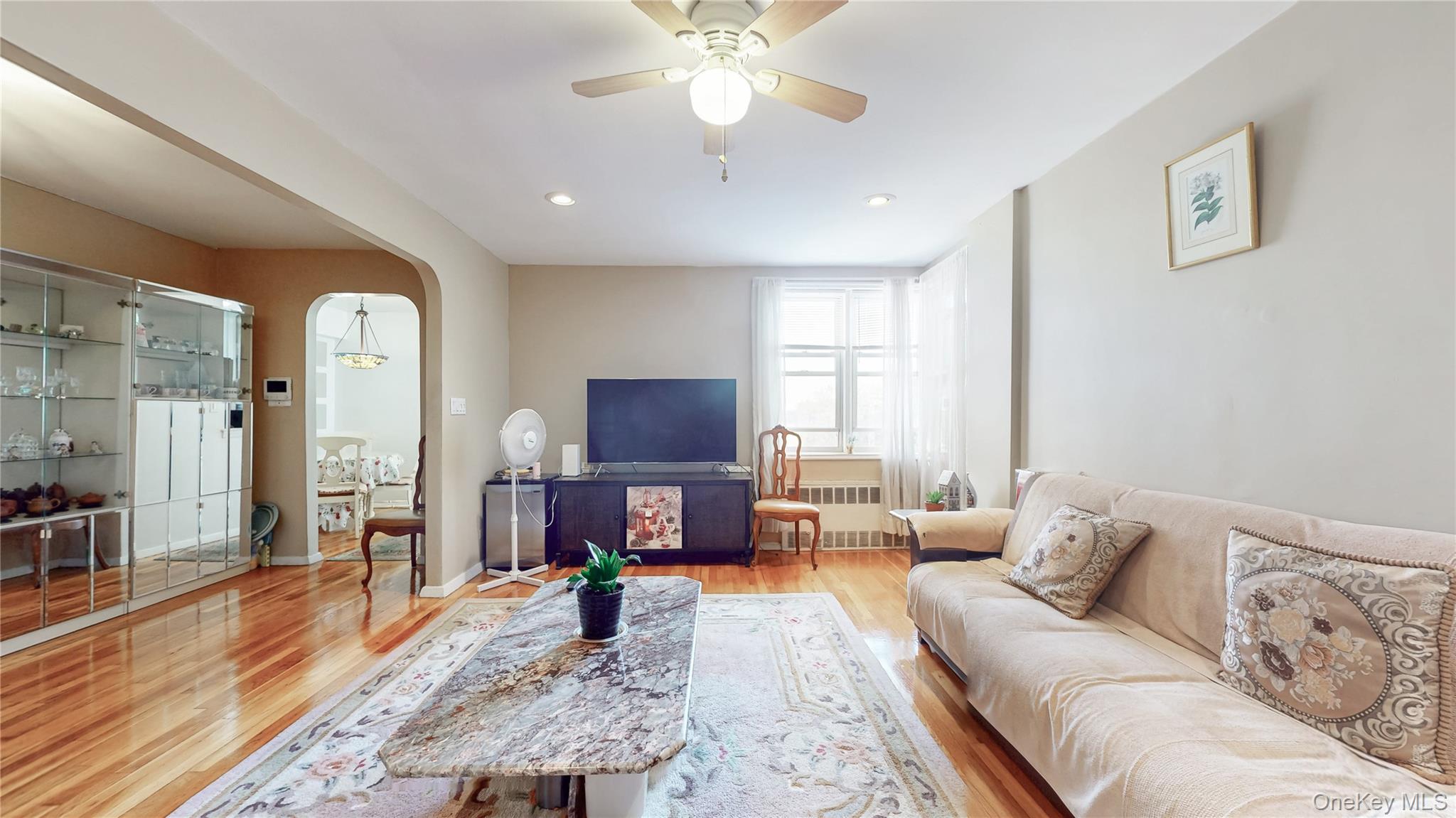 67-40 Booth Street, Unit 4O Queens, NY 11375 - Photo 5 of 19 a living room with furniture a fireplace and a flat screen tv