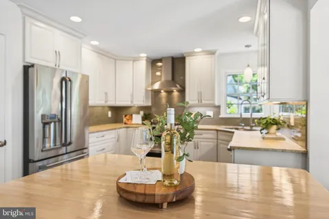 a large white kitchen with furniture and a chandelier