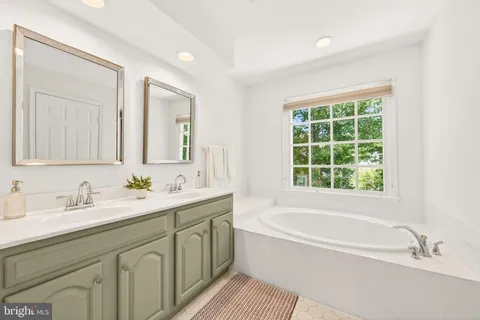 a bathroom with a tub a sink and a window