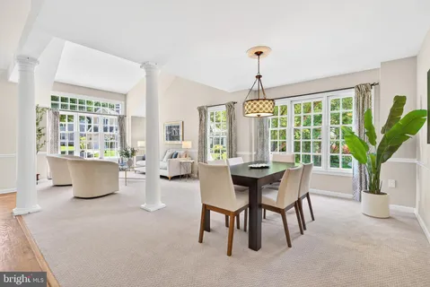 a dining room with furniture a chandelier and wooden floor