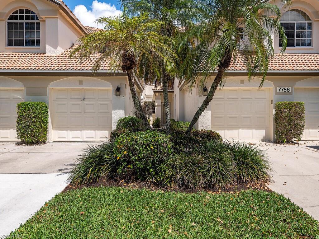 7756 Gardner Drive, Unit 102 Naples, FL 34109 - Photo 12 of 16 a front view of a house with garden