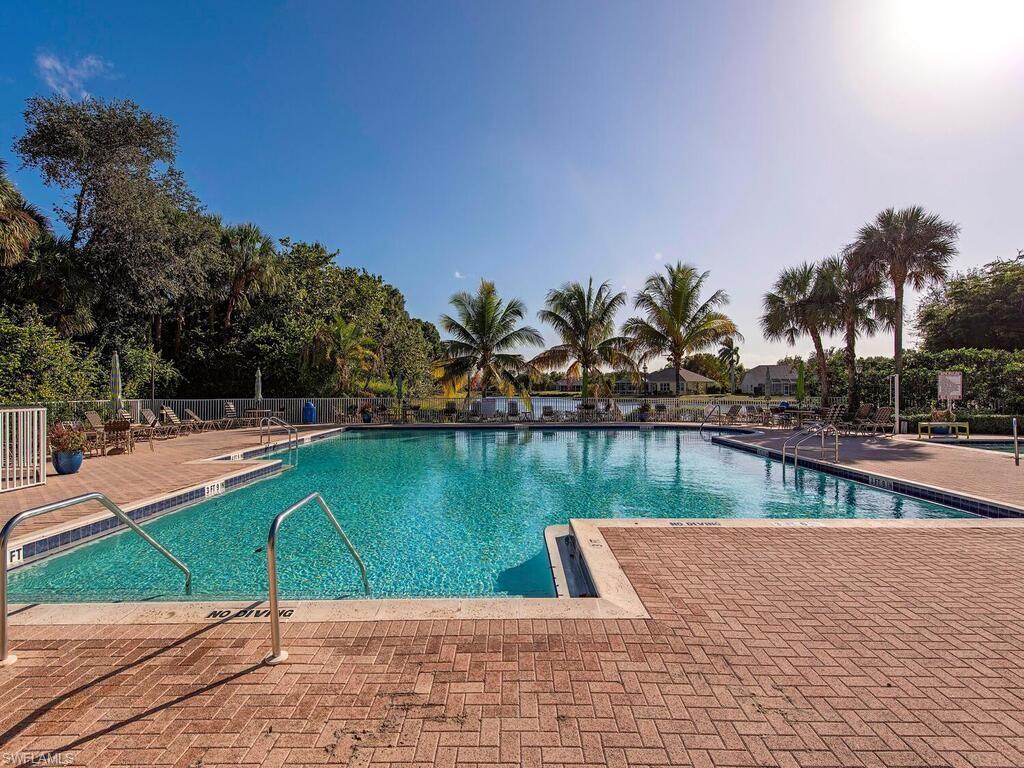 7756 Gardner Drive, Unit 102 Naples, FL 34109 - Photo 14 of 16 a view of a swimming pool with a lake view
