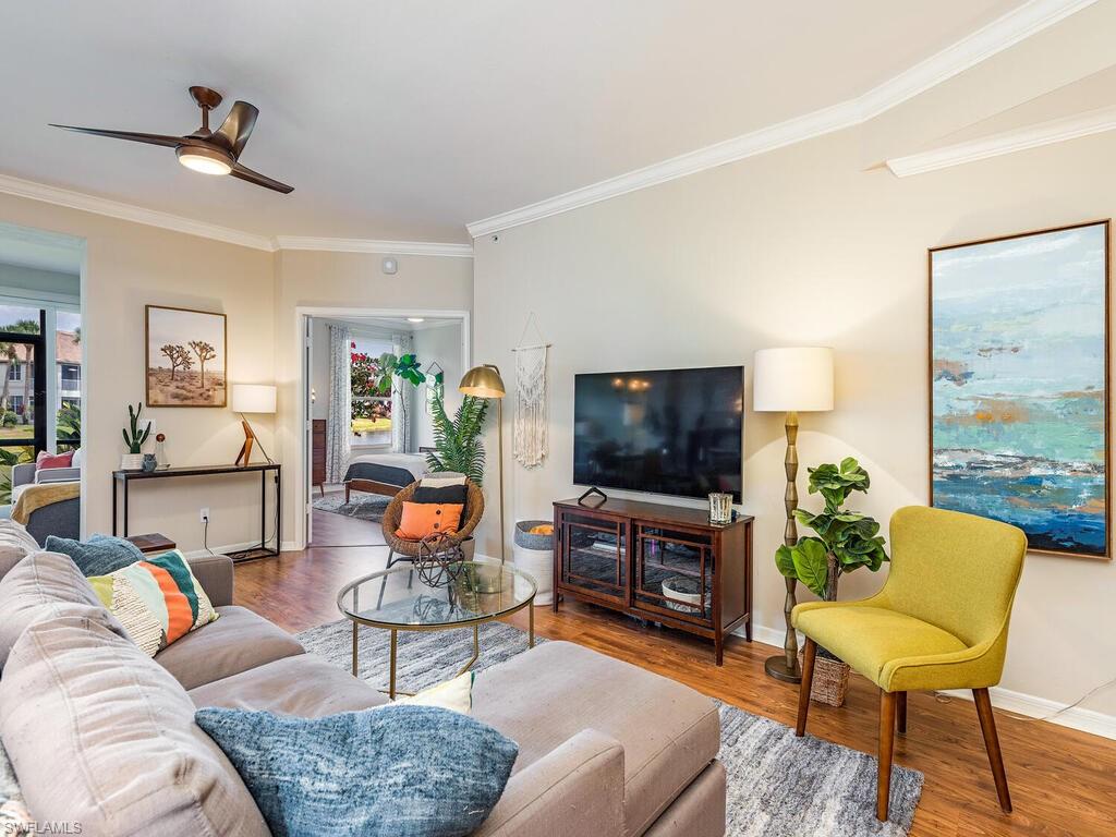 7756 Gardner Drive, Unit 102 Naples, FL 34109 - Photo 3 of 16 a living room with furniture and a flat screen tv