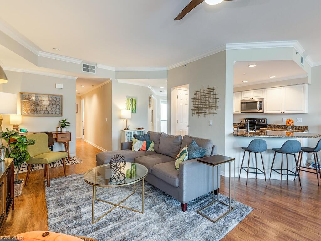 7756 Gardner Drive, Unit 102 Naples, FL 34109 - Photo 4 of 16 a living room with furniture and wooden floor