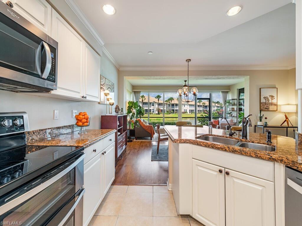 7756 Gardner Drive, Unit 102 Naples, FL 34109 - Photo 5 of 16 a kitchen with a sink and microwave