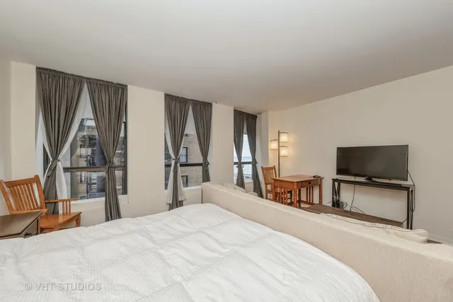 a bedroom with a bed and a flat tv screen on wall