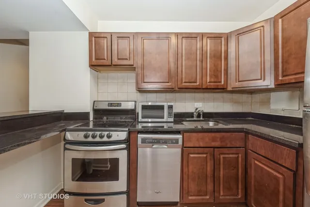 a kitchen with granite countertop a stove sink and cabinets