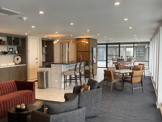 a living room with furniture kitchen view and a wooden floor