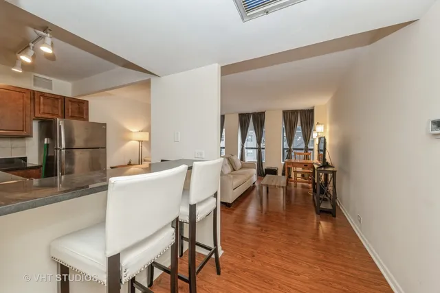 a kitchen with a table chairs refrigerator and microwave