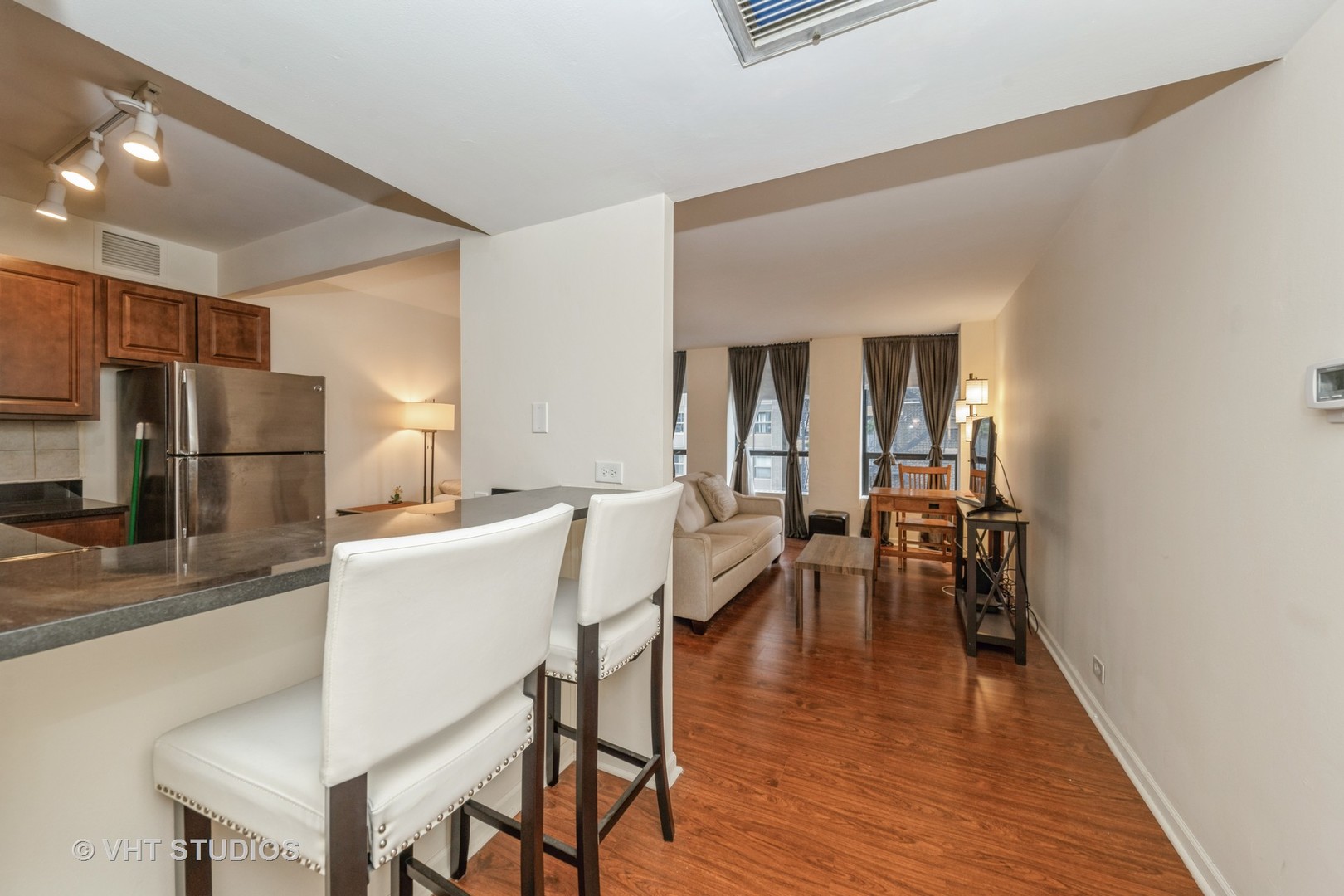 260 East Chestnut Street, Unit 606 Chicago, IL 60611 - Photo 4 of 27 a kitchen with a table chairs refrigerator and microwave