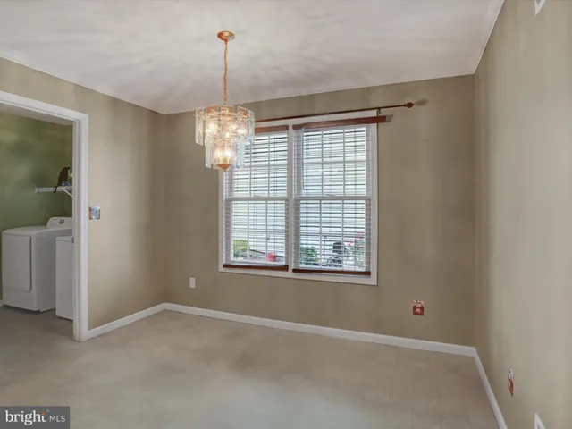 an empty room with chandelier and windows