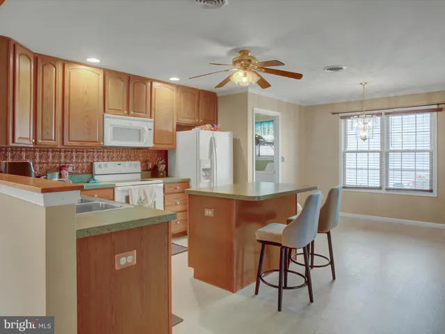 a kitchen with stainless steel appliances granite countertop a stove a sink a refrigerator and island