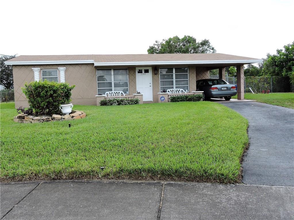 3384 Northwest 17th Street Lauderhill, FL 33311 - Photo 1 of 24 a front view of a house with a garden