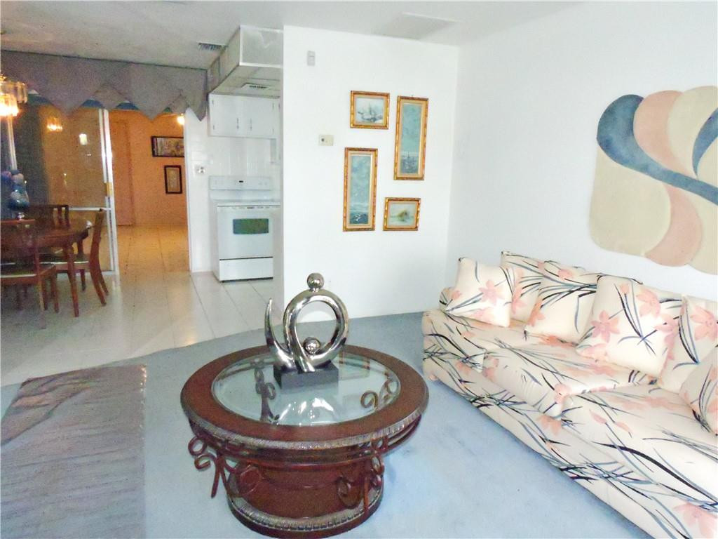 3384 Northwest 17th Street Lauderhill, FL 33311 - Photo 4 of 24 a living room with furniture a dining table and a chandelier