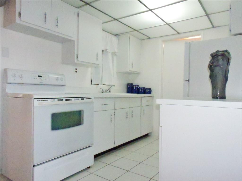 3384 Northwest 17th Street Lauderhill, FL 33311 - Photo 8 of 24 a kitchen with white cabinets and white appliances