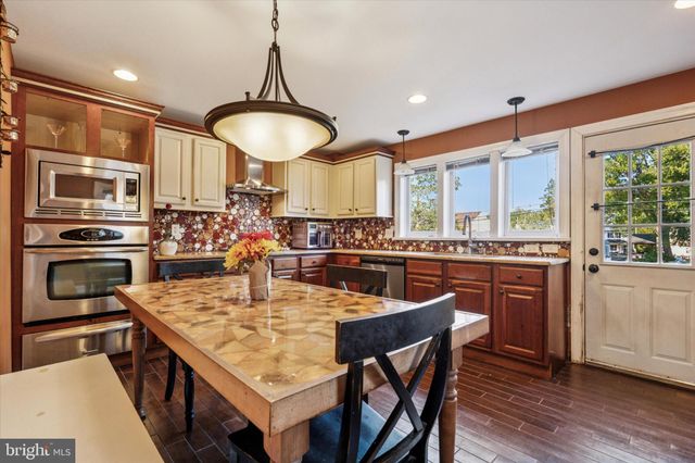 a kitchen with stainless steel appliances granite countertop a stove a sink a microwave a center island and a refrigerator