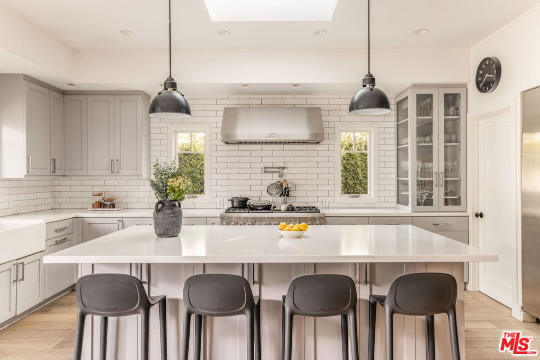 9617 Kirkside Road Los Angeles, CA 90035 - Photo 5 of 14 a kitchen with a sink a center island and cabinets