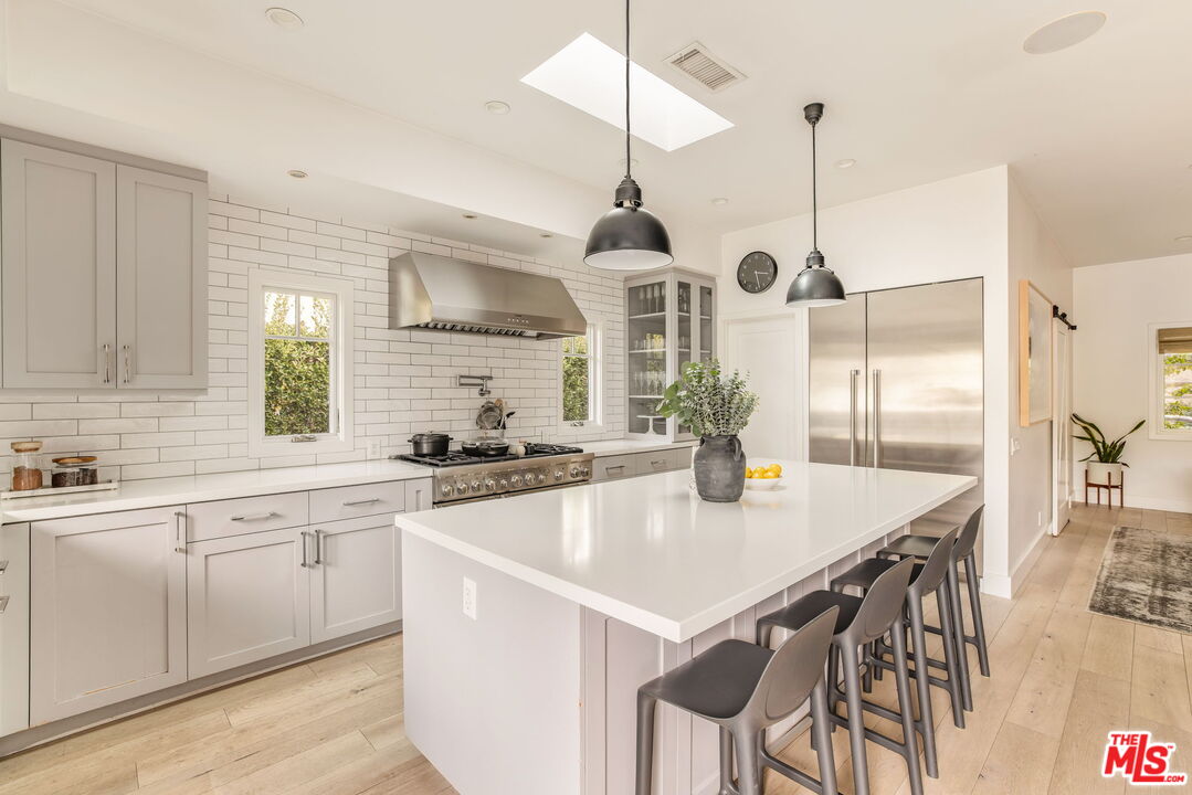 9617 Kirkside Road Los Angeles, CA 90035 - Photo 6 of 14 a kitchen with stainless steel appliances granite countertop a sink a stove and chairs