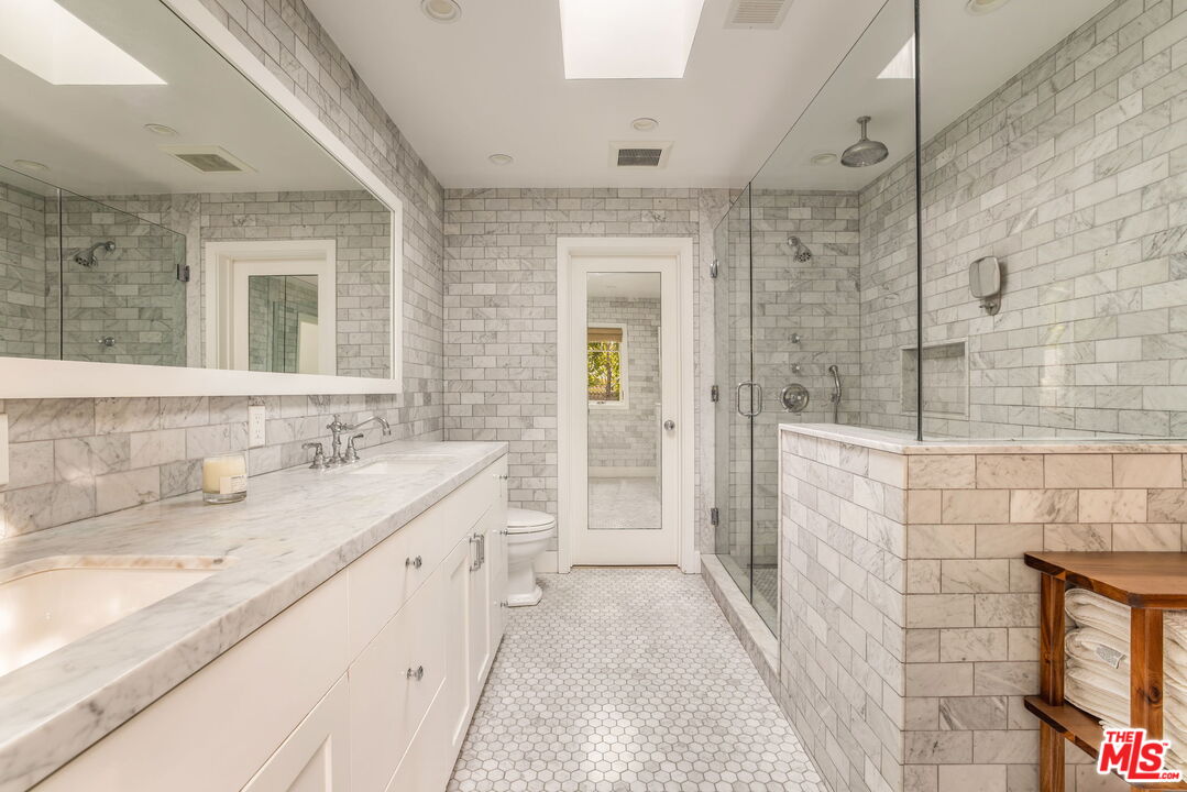 9617 Kirkside Road Los Angeles, CA 90035 - Photo 10 of 14 a spacious bathroom with a granite countertop sink a toilet a mirror and shower