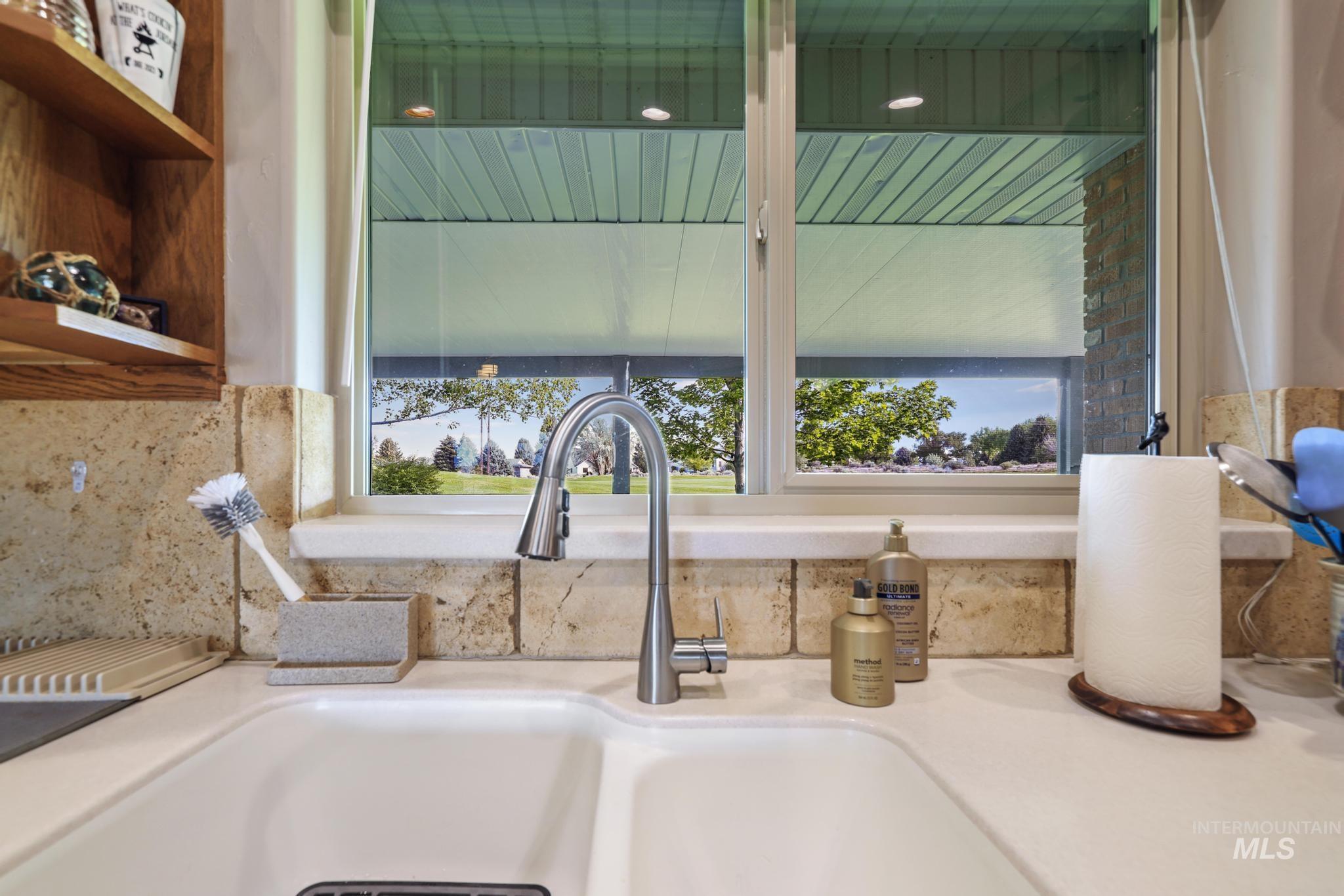 100 Olympic Road Jerome, ID 83338 - Photo 17 of 50 White dual-basin sink with a contemporary chrome faucet set against a stone tile backsplash