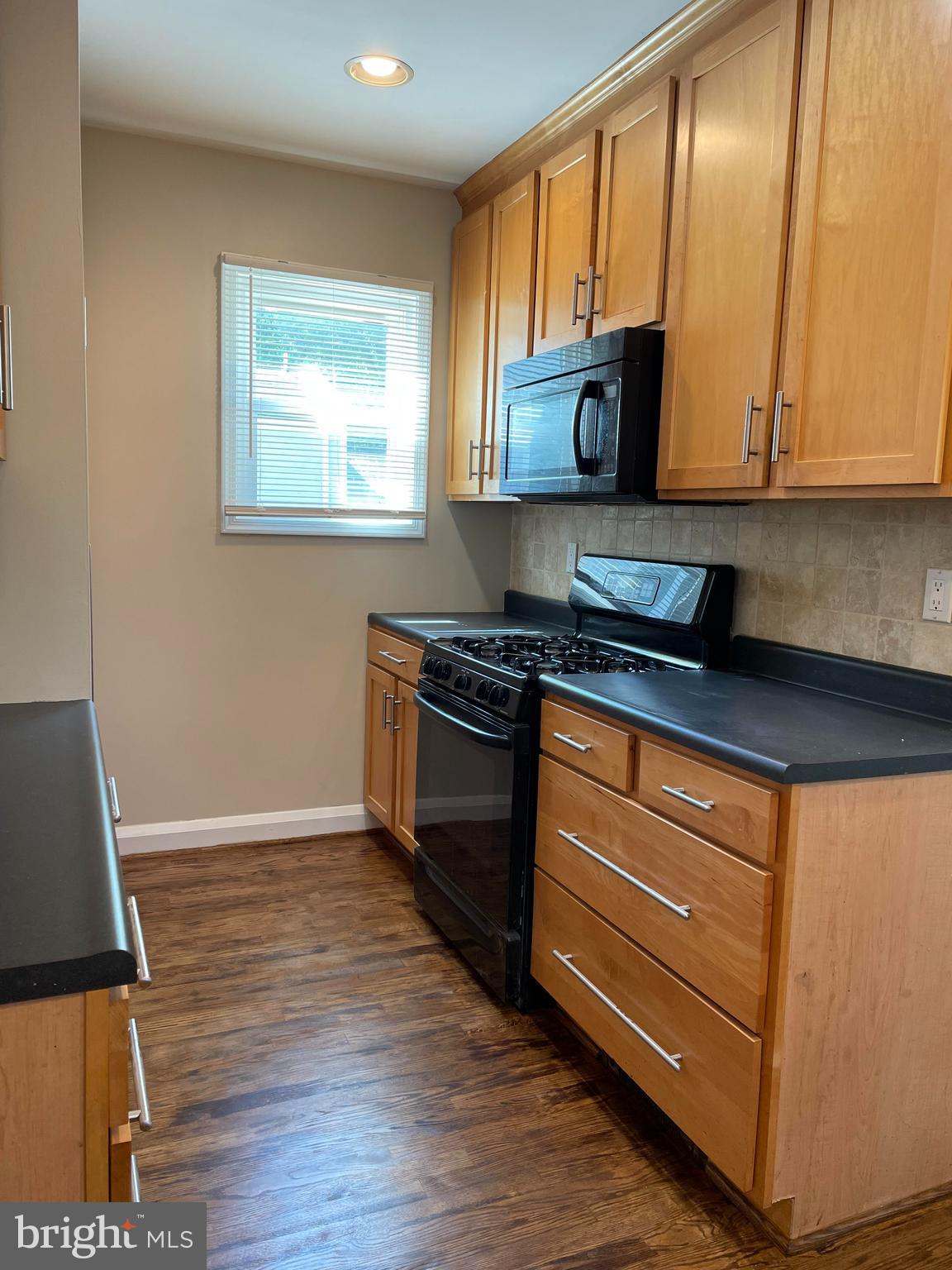 922 Overbrook Road Baltimore, MD 21239 - Photo 6 of 15 a kitchen with granite countertop wooden cabinets and a stove top oven